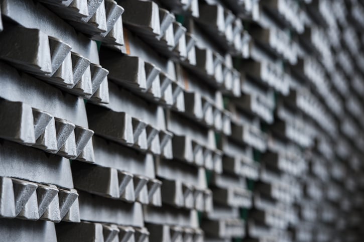 Aluminum ingots stacked in a warehouse.