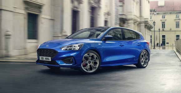 A blue 2019 Ford Focus ST, a sporty hatchback, on a European street. 