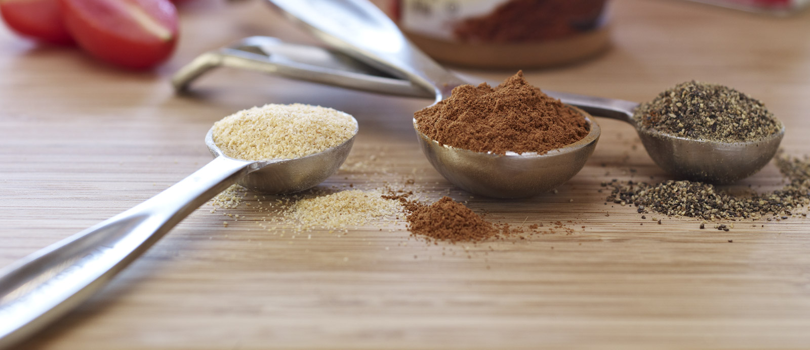 A selection of different spices in teaspoons.