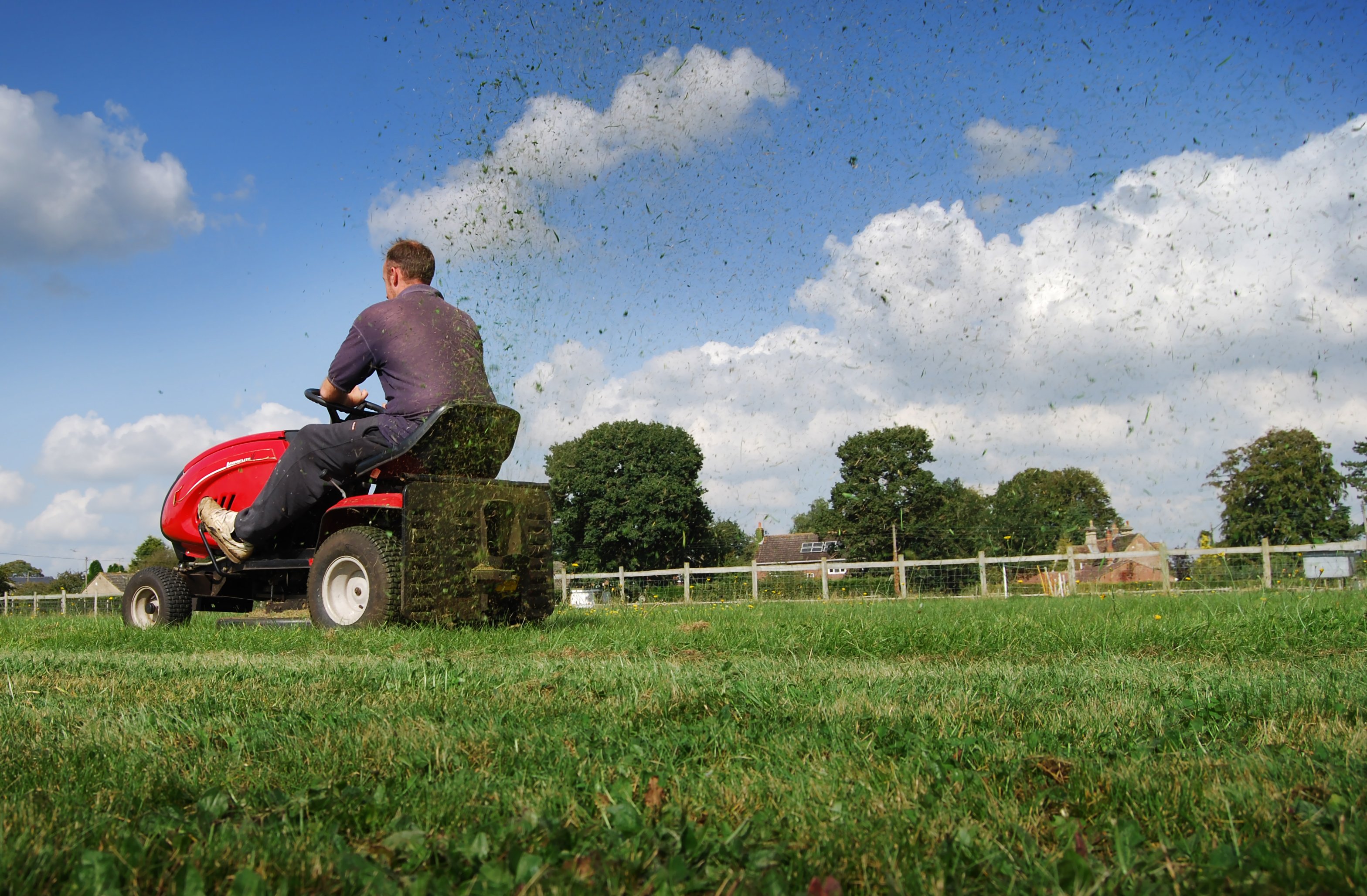 Man on riding lawn mower. 