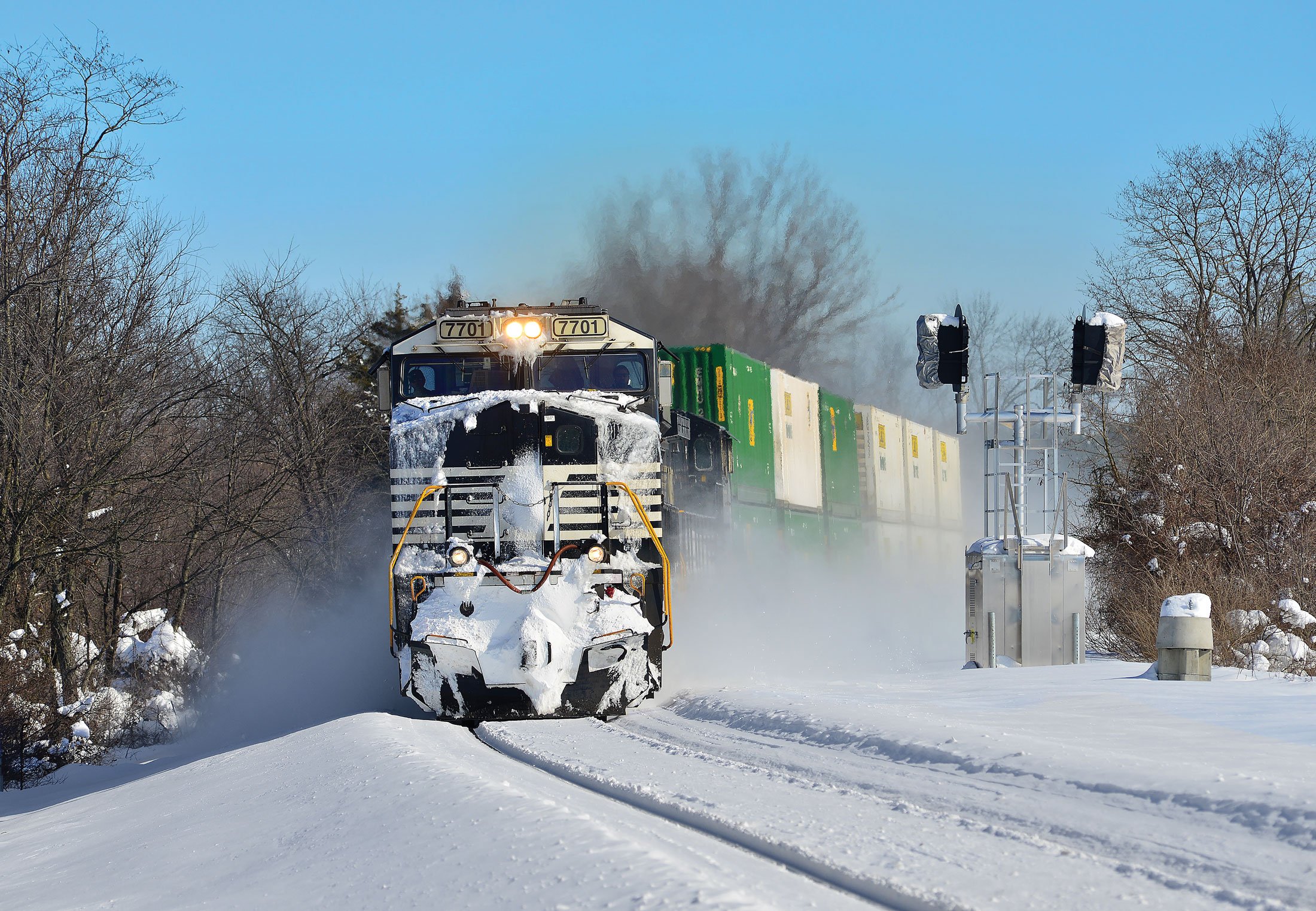 Locomotive pushing through snow. 