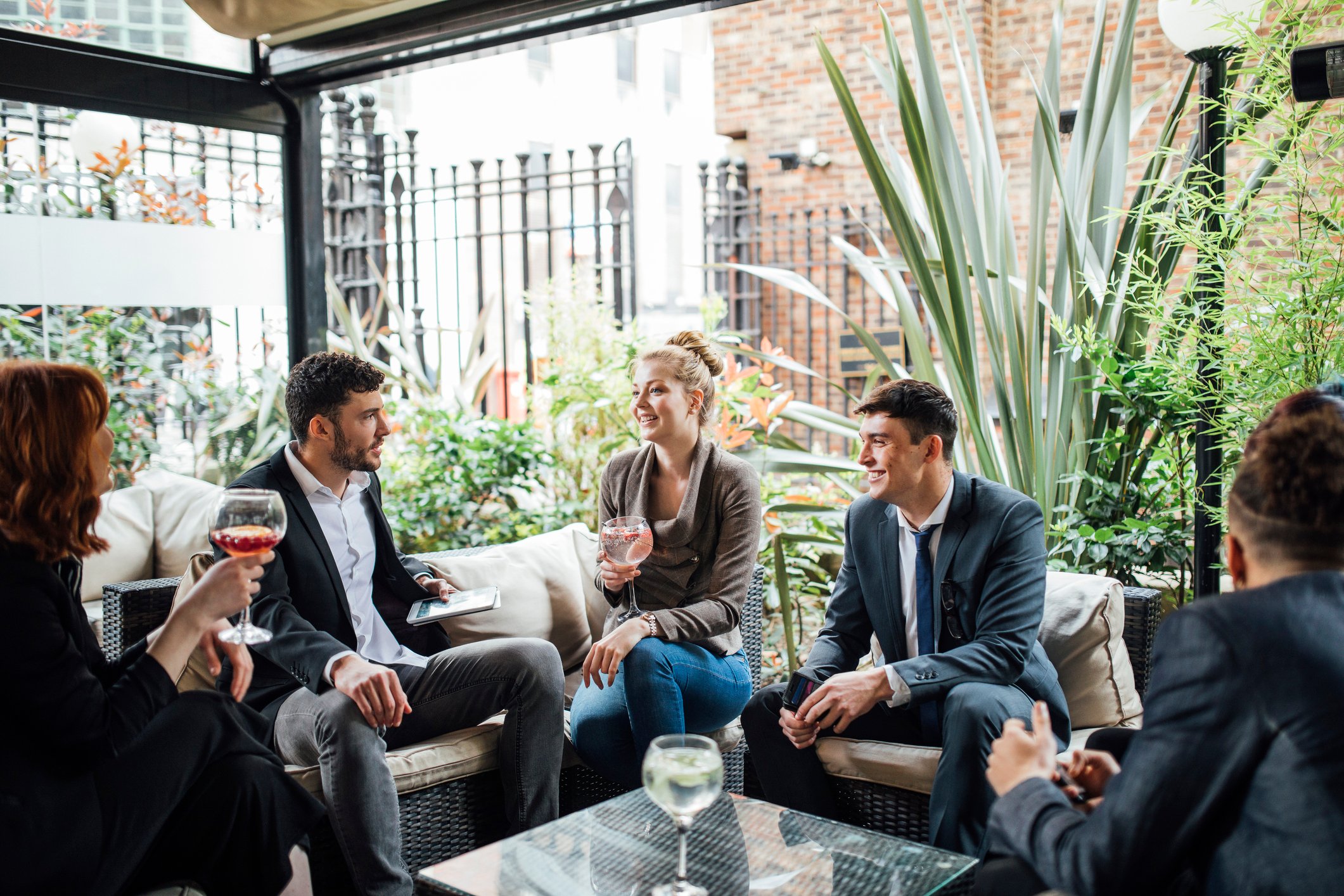 Professionals sitting around with wine glasses.