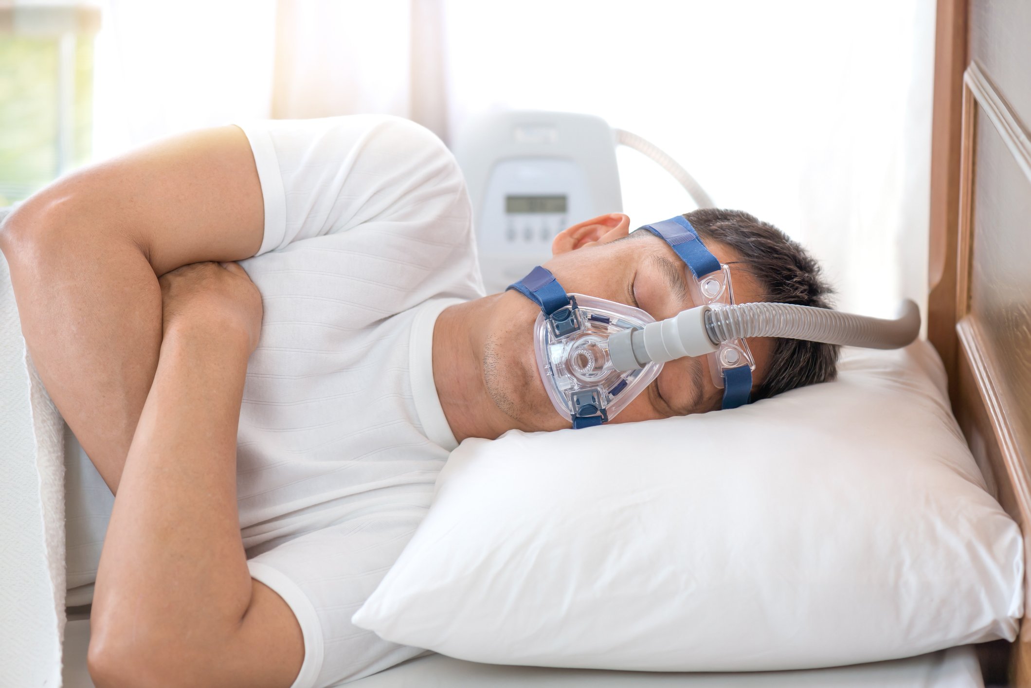 Sleeping man wearing CPAP mask.