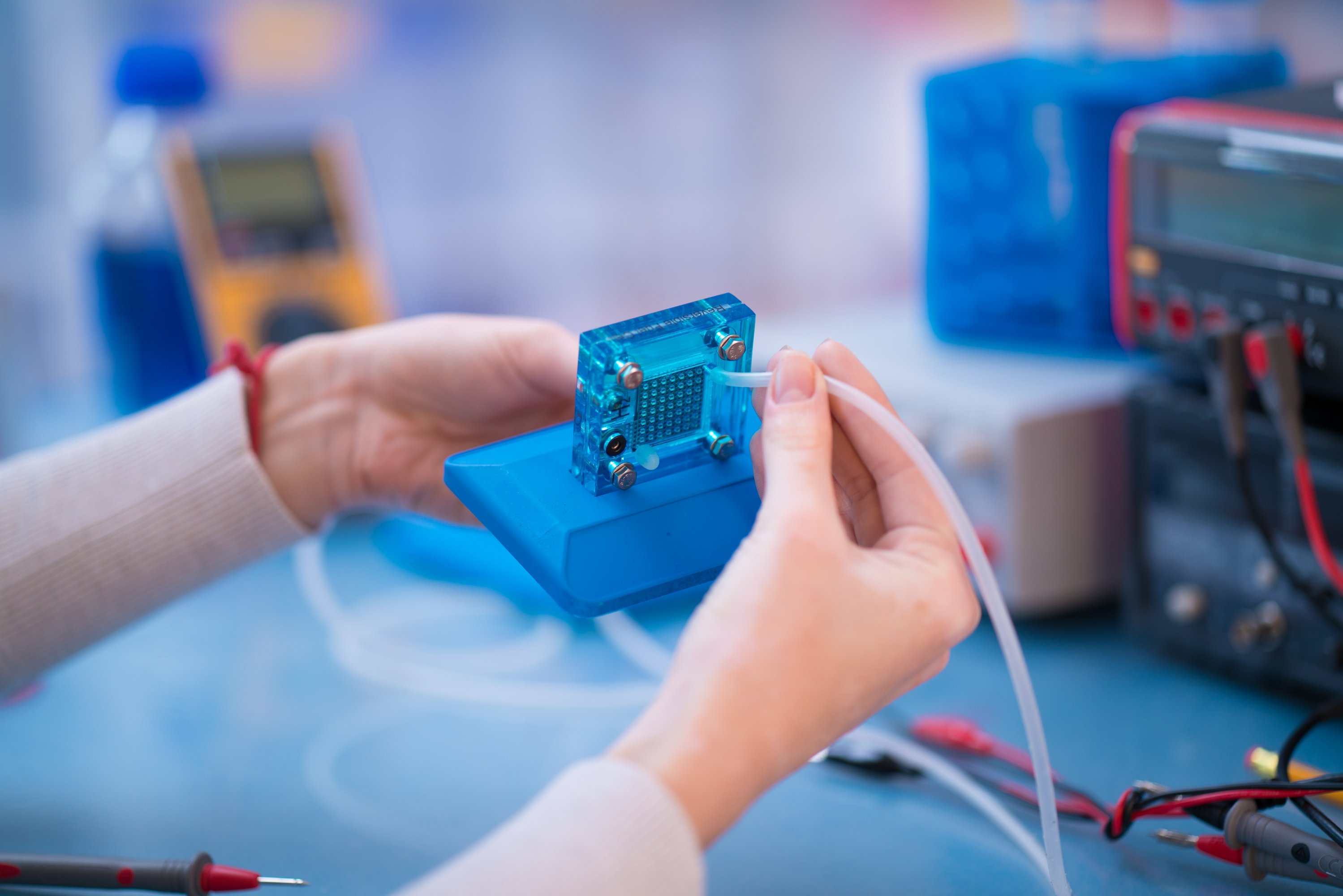 Woman's hands assembling a square fuel cell