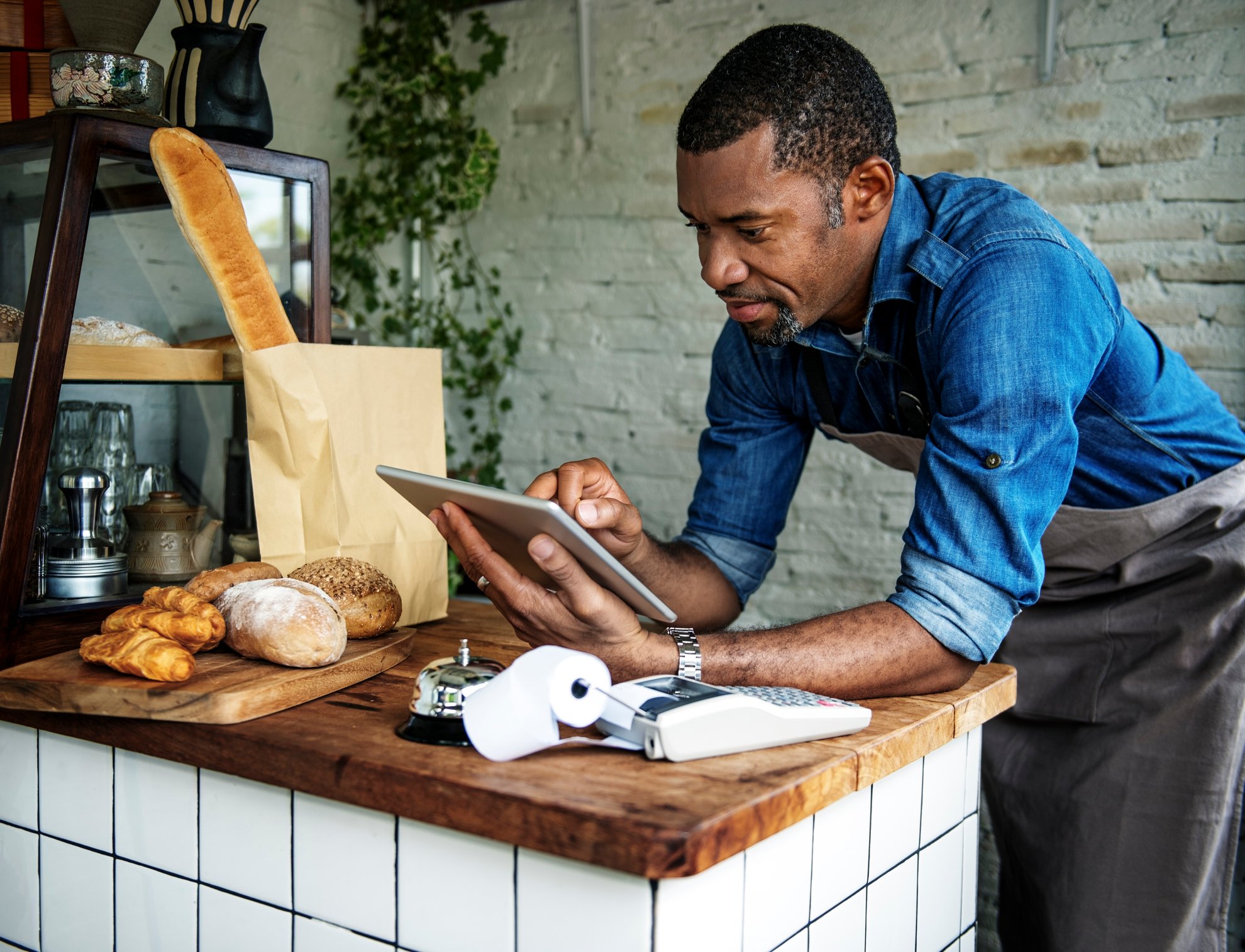 A cafe owner orders supplies on a tablet device.