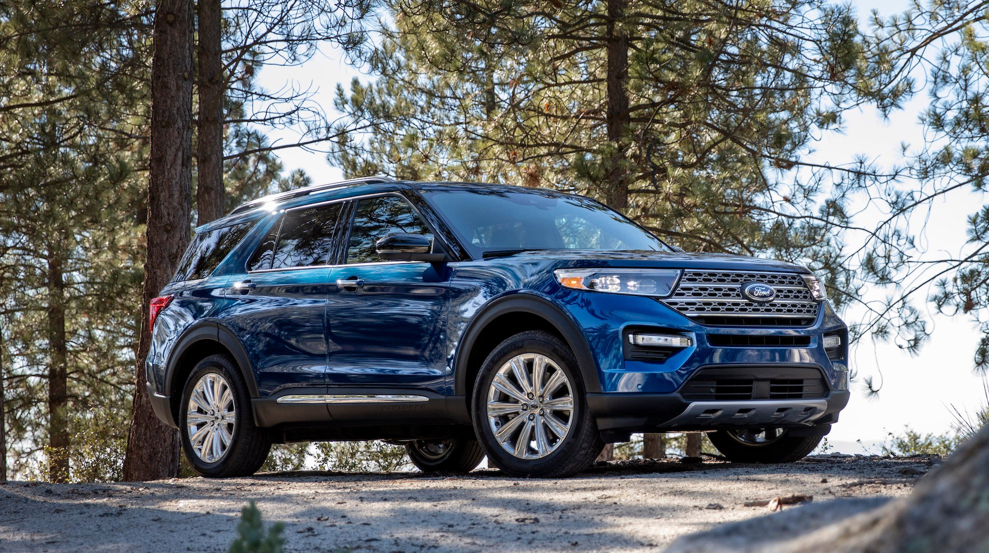 A blue 2020 Ford Explorer, a seven-passenger crossover SUV, parked in a wooded setting