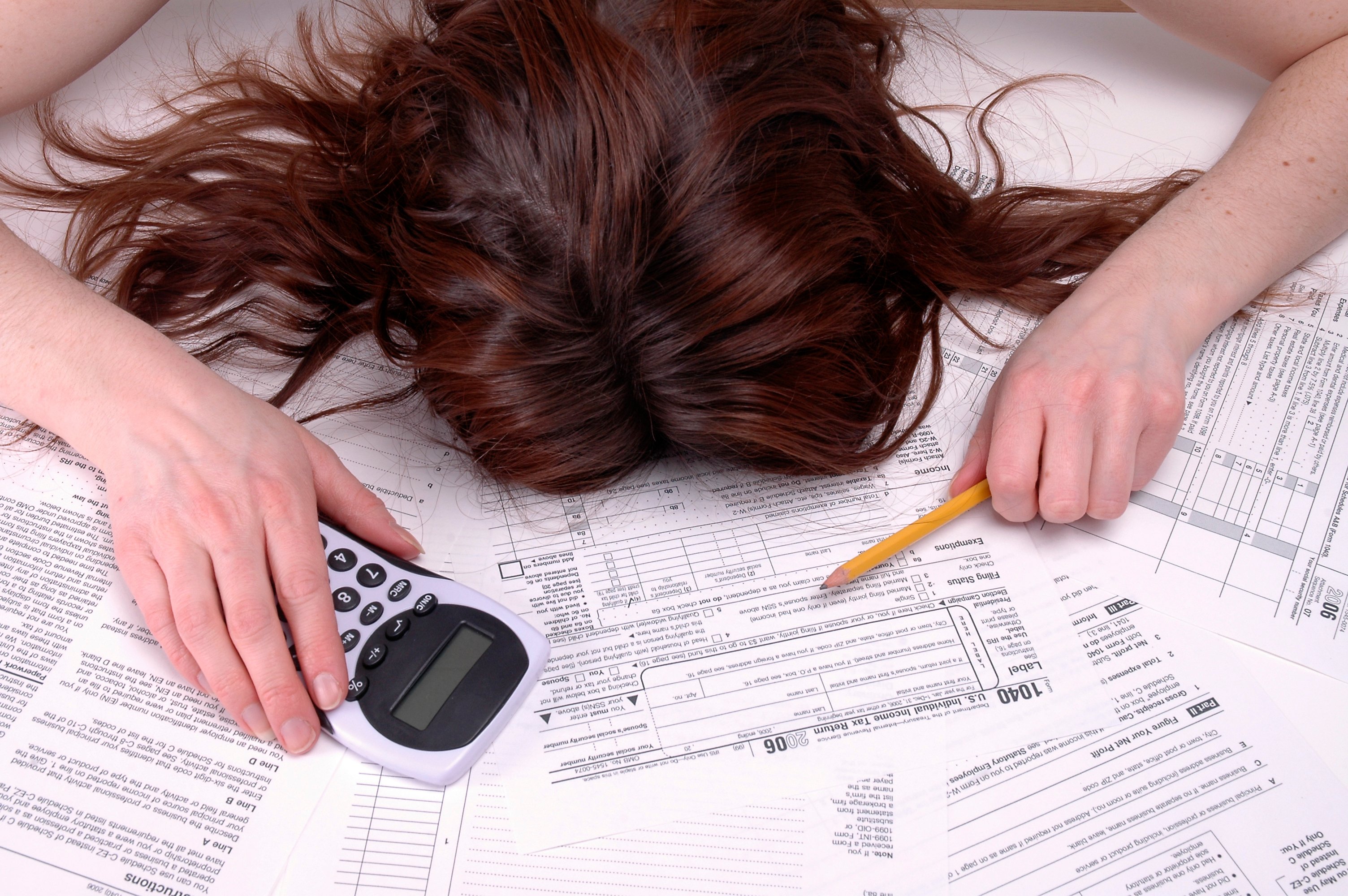 Woman collapsed over tax forms.