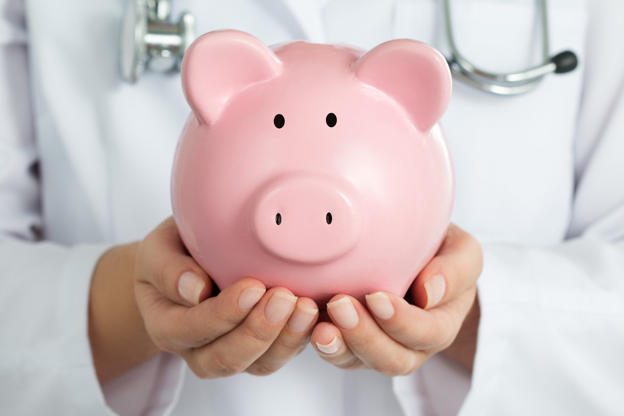 A doctor holding a piggy bank.