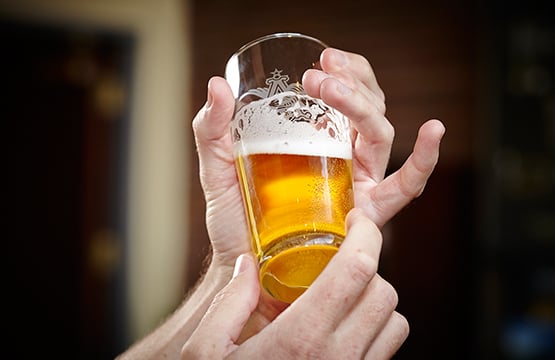 Hand holding a full beer glass