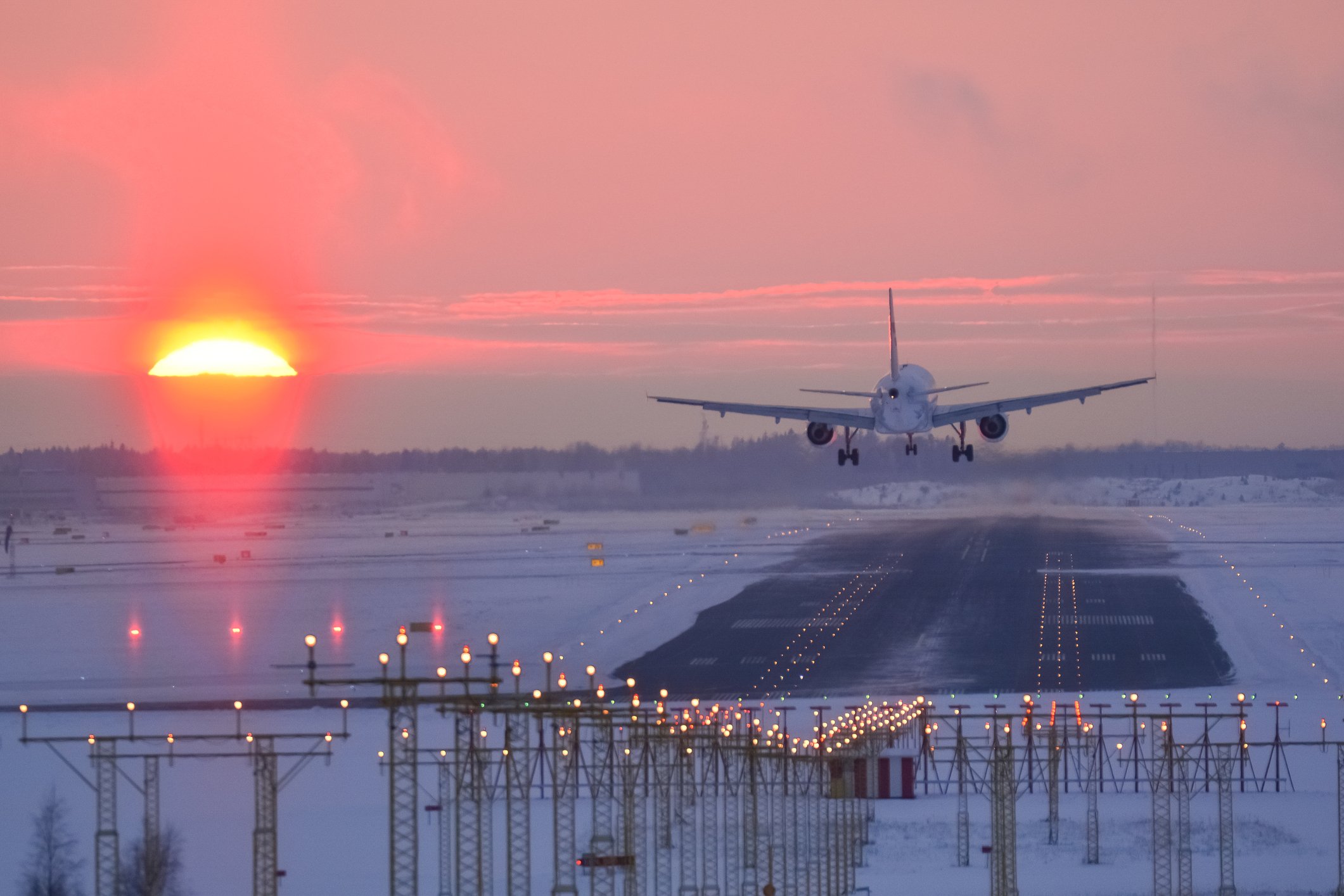 A plane landing during sunset. 