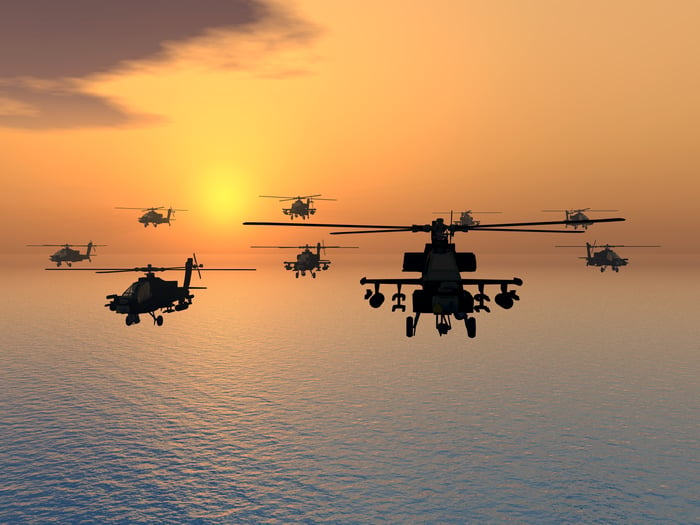 Military helicopters in flight over the ocean