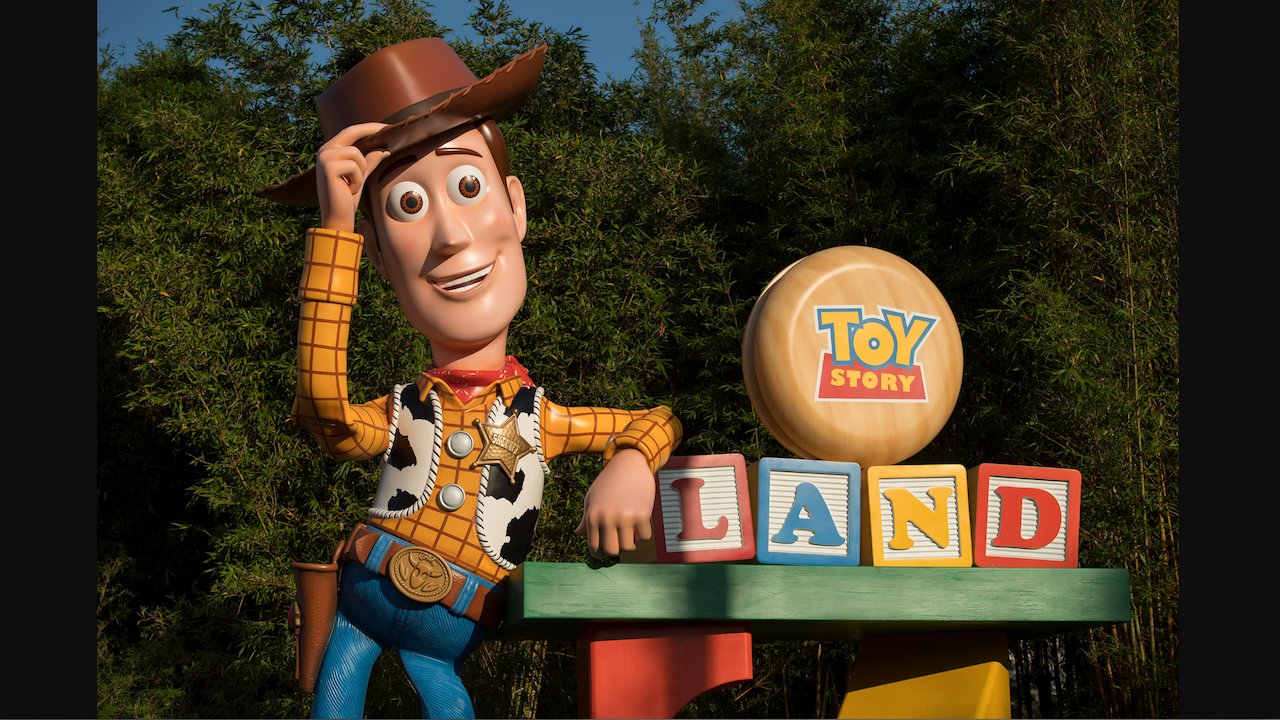 Woody figure in front of the Toy Story Land entrance at Disney's Hollywood Studios in Florida.