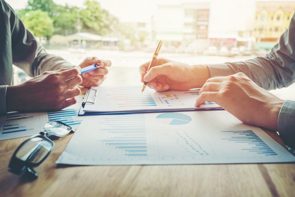 People performing market research with charts on a table