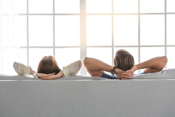 A worry-free couple relaxing on a sofa.