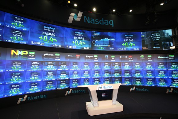 An indoor television studio at the Nasdaq exchange, complete with the electronic big board in the background.