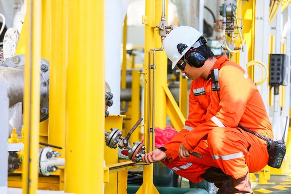 Worker installing a part on an oil rig.