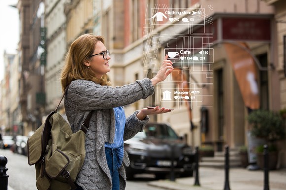 A woman uses a pair of AR glasses on the street.