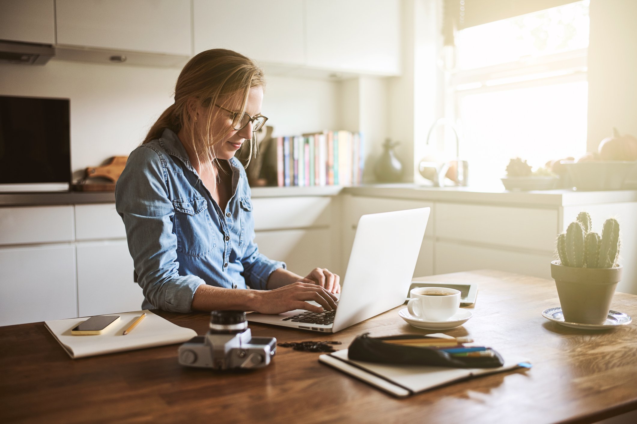 Woman on laptop in kitchen.