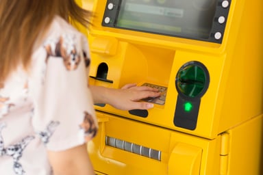 Woman Using Bright Yellow ATM