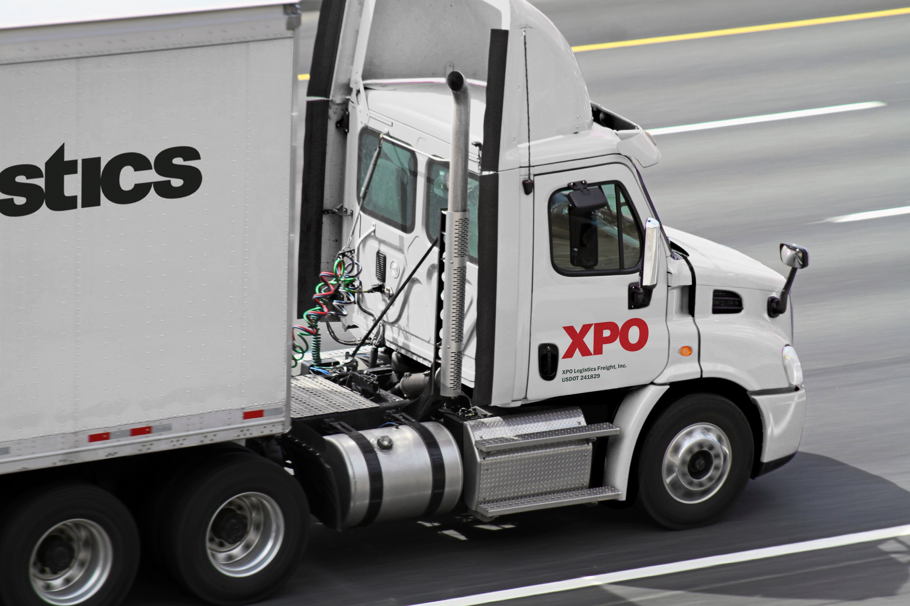 Semi-trailer truck with XPO logo on it on a highway
