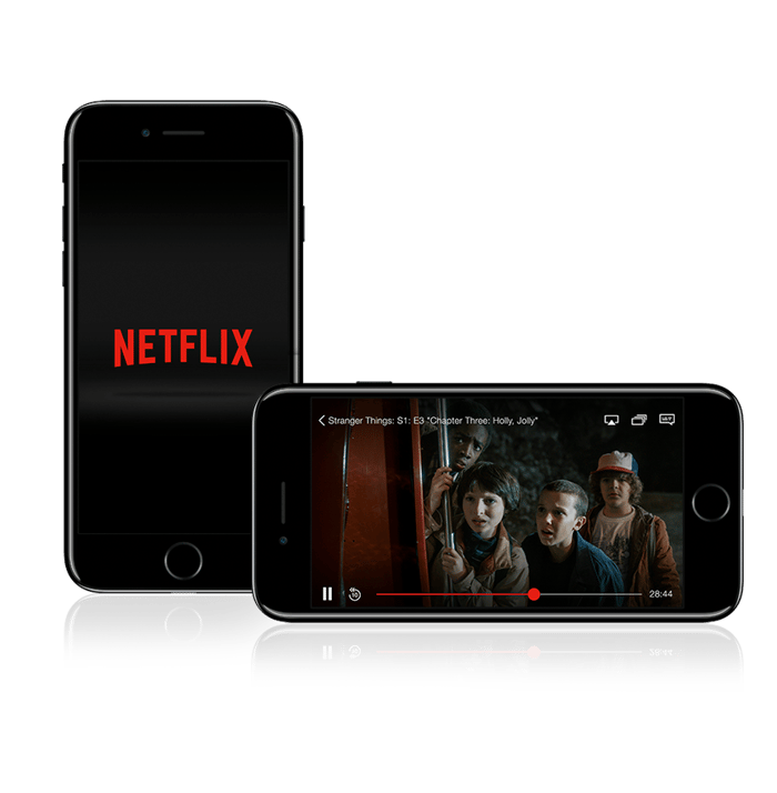 One iPhone standing vertically showing the Netflix logo, and another laying landscape showing a scene from the Netflix original series Stranger Things
