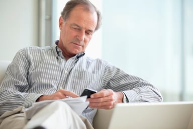 older man looking at papers_GettyImages-135385084