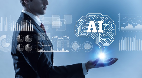 An artistic depiction of a man holding out his hand, which is holding a computer-chip brain that says "AI"