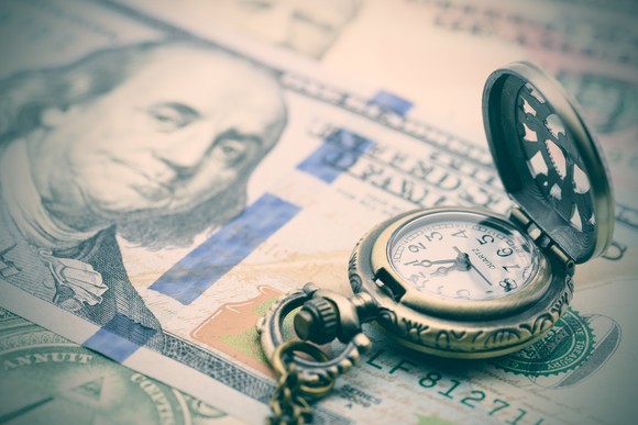 A pocket watch on a hundred-dollar bill.