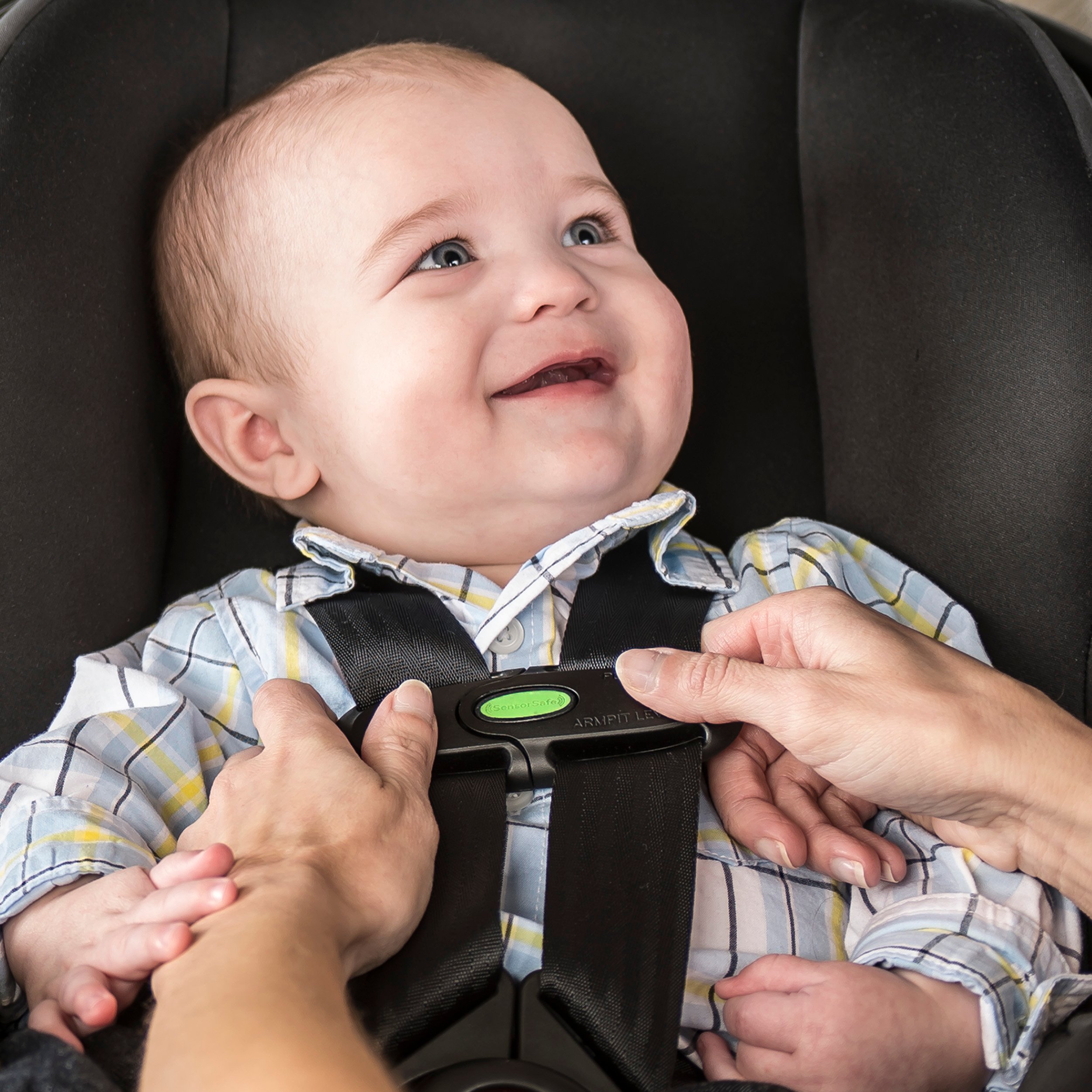 A baby is snapped into a car seat.