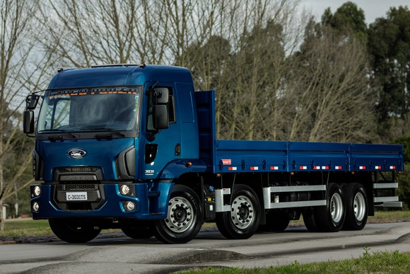 A Ford Cargo truck, a small tractor-trailer with a flatbed. 