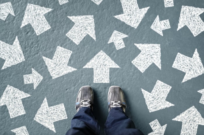 person standing surrounded by arrows pointing in different directions