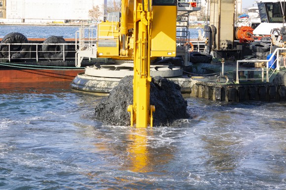 Excavator dredging a river