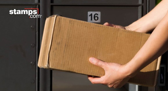 Two arms holding a box in front of a row of large post office boxes, with Stamps.com logo in the corner.