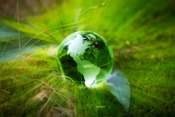 A green globe sitting on the grass