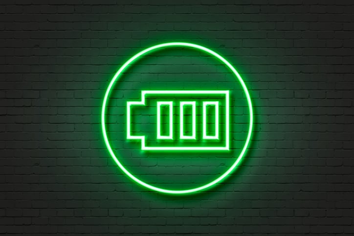 A green neon light in the shape of a battery.