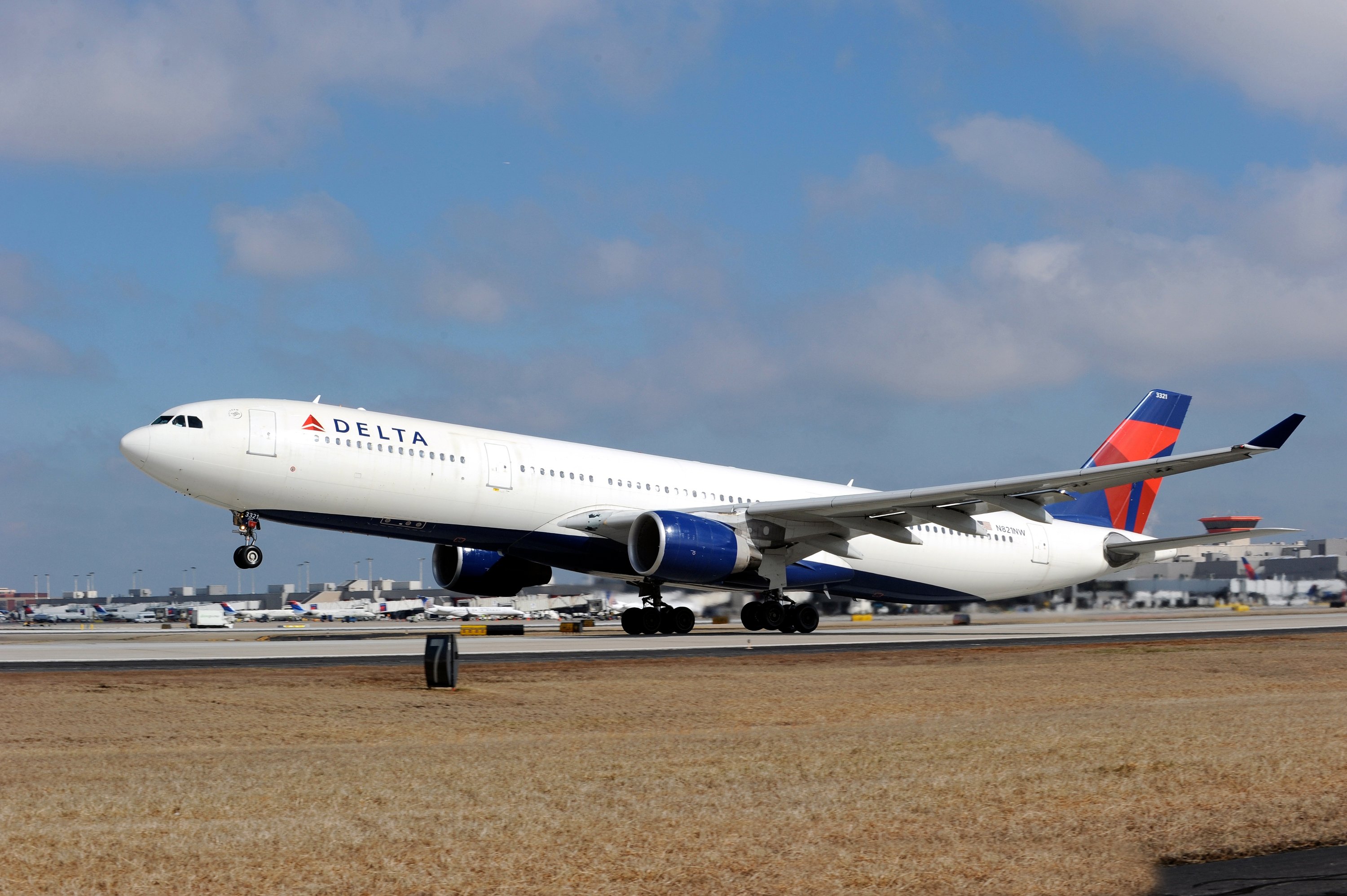 A Delta Air Lines A330 jet landing on a runway