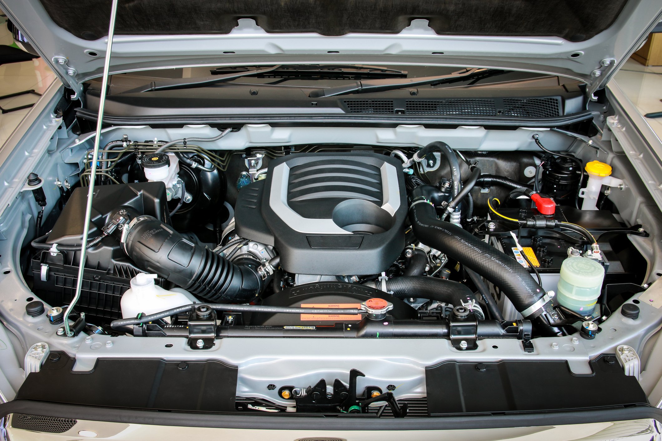 Car engine with hood popped open.