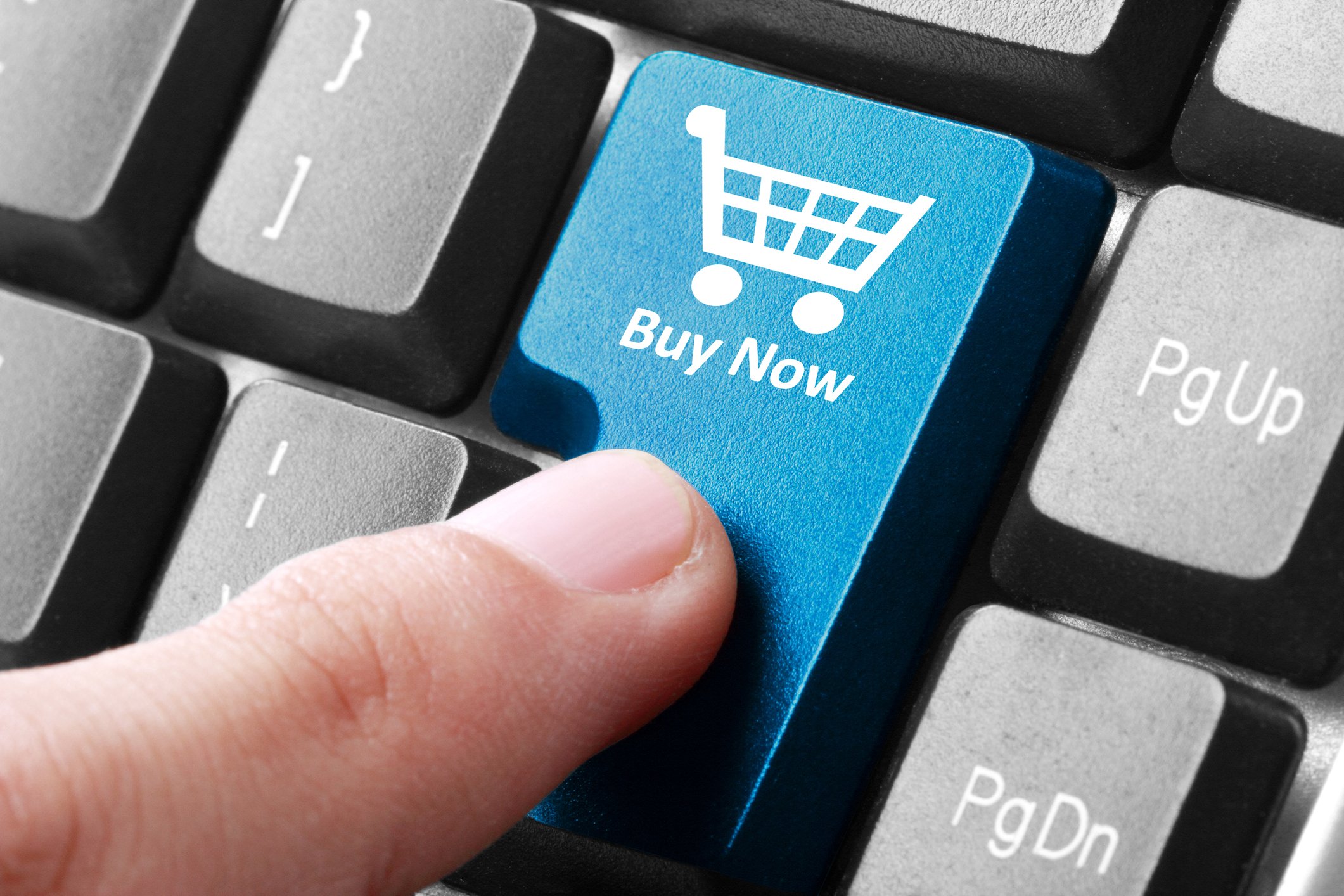An index finger preparing to hit a "buy now" button on a keyboard