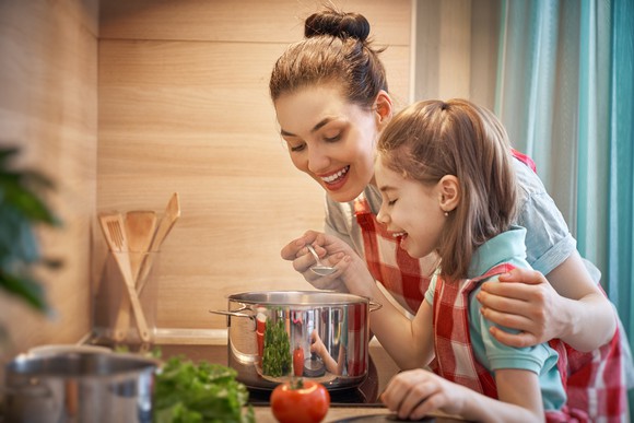 Woman and child heating up soup together