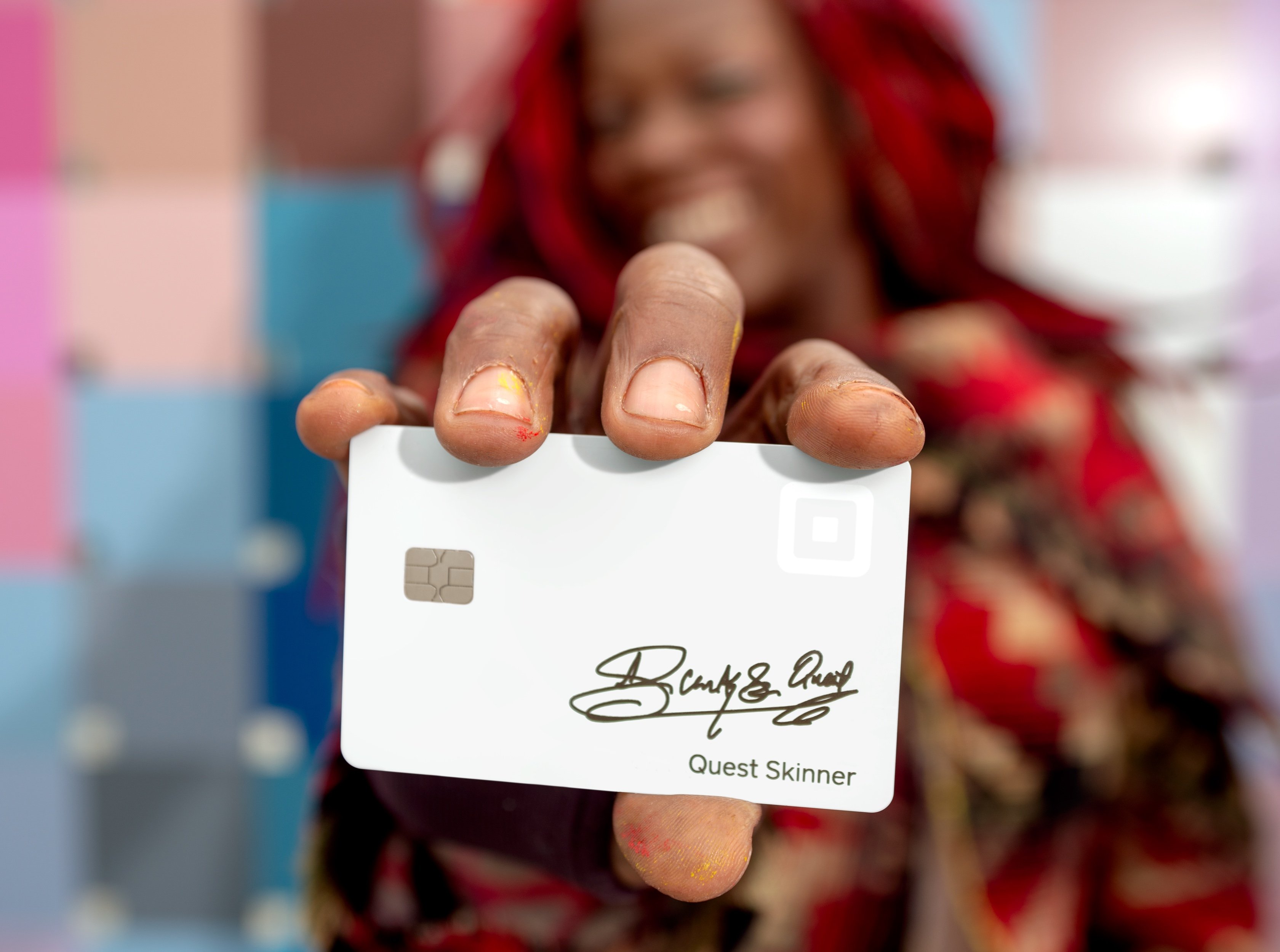 Square card being held by artist Quest Skinner