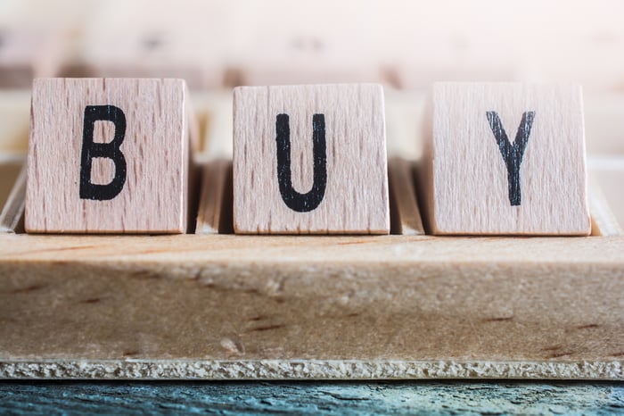 Close-up of the word Buy formed by wooden blocks.
