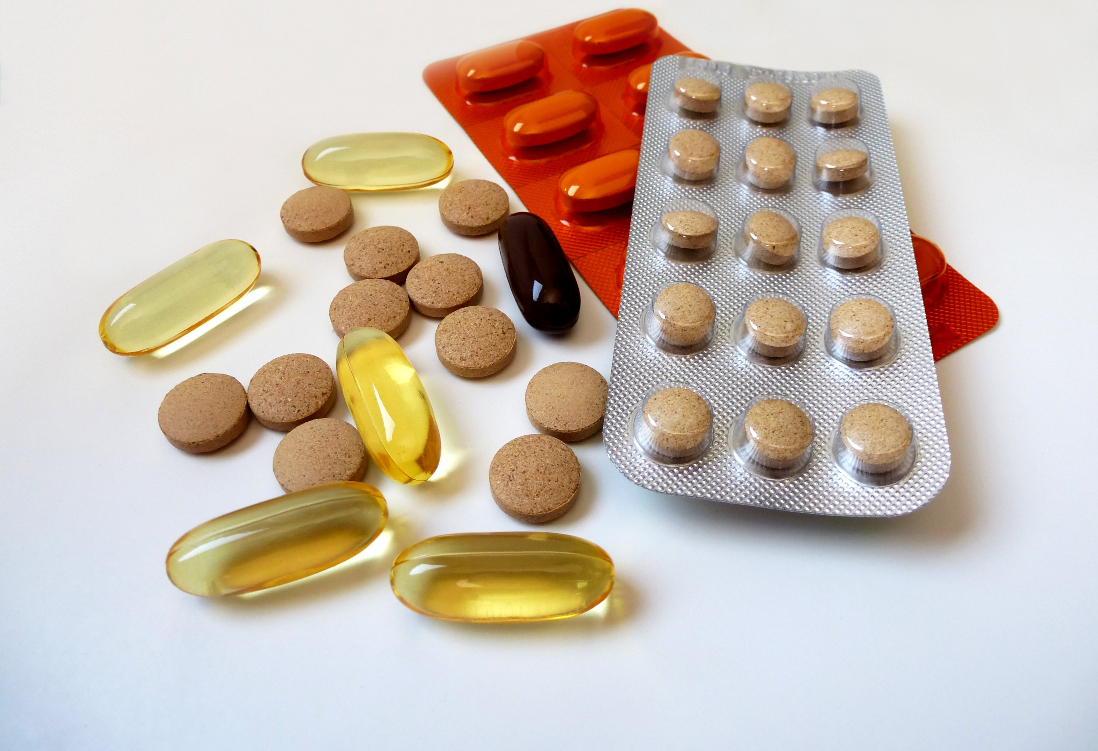 Supplements in several forms (tablet, capsule, softgel) on a table.