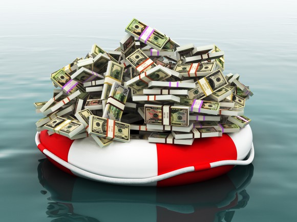 Pile of money floating in a life preserver.