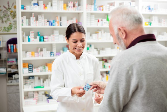 A pharmacist helps an old man.