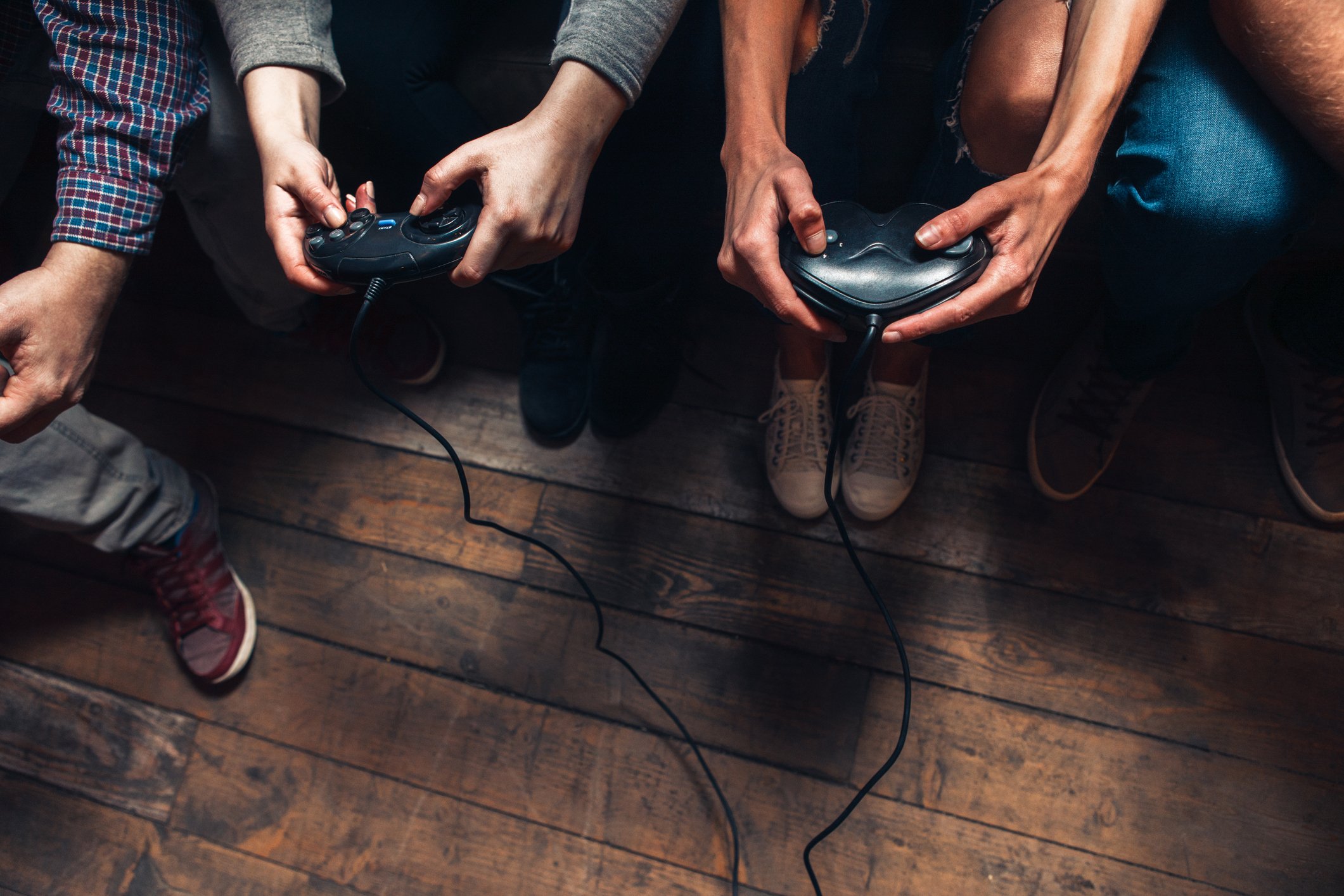 A pair of men's hands holding video game controllers.