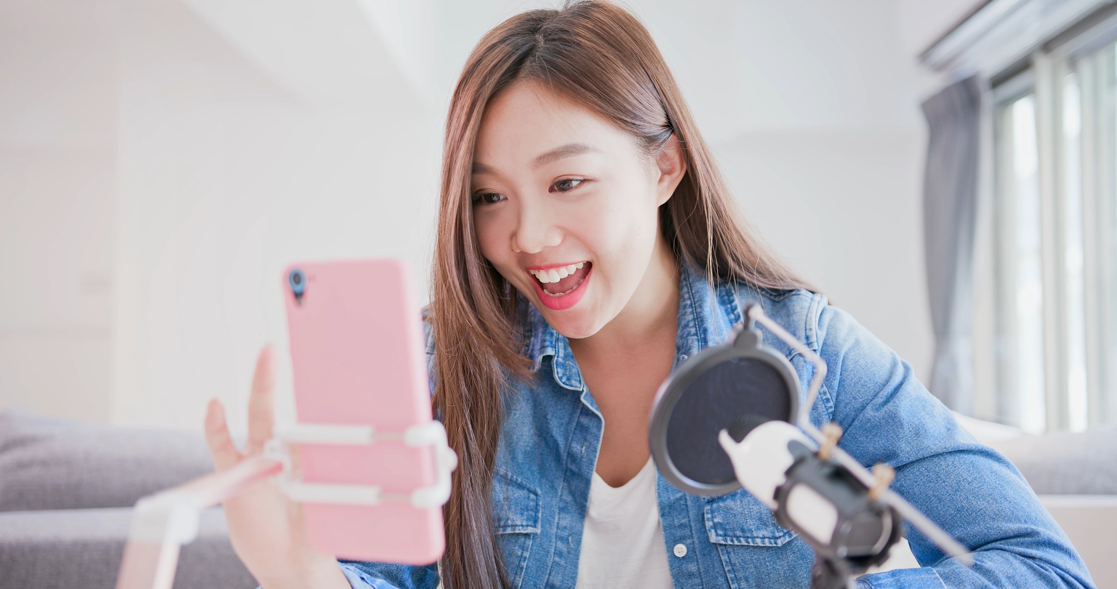 A young woman broadcasts a live video from her smartphone.