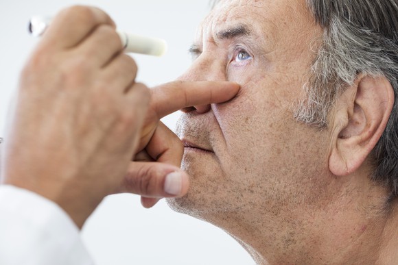 An elderly man having an eye exam.