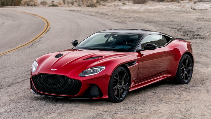 A red Aston Martin DBS Superleggera, a sleek high-performance supercar. 