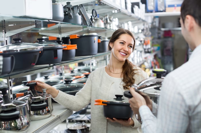 A woman in a store holding cookware.