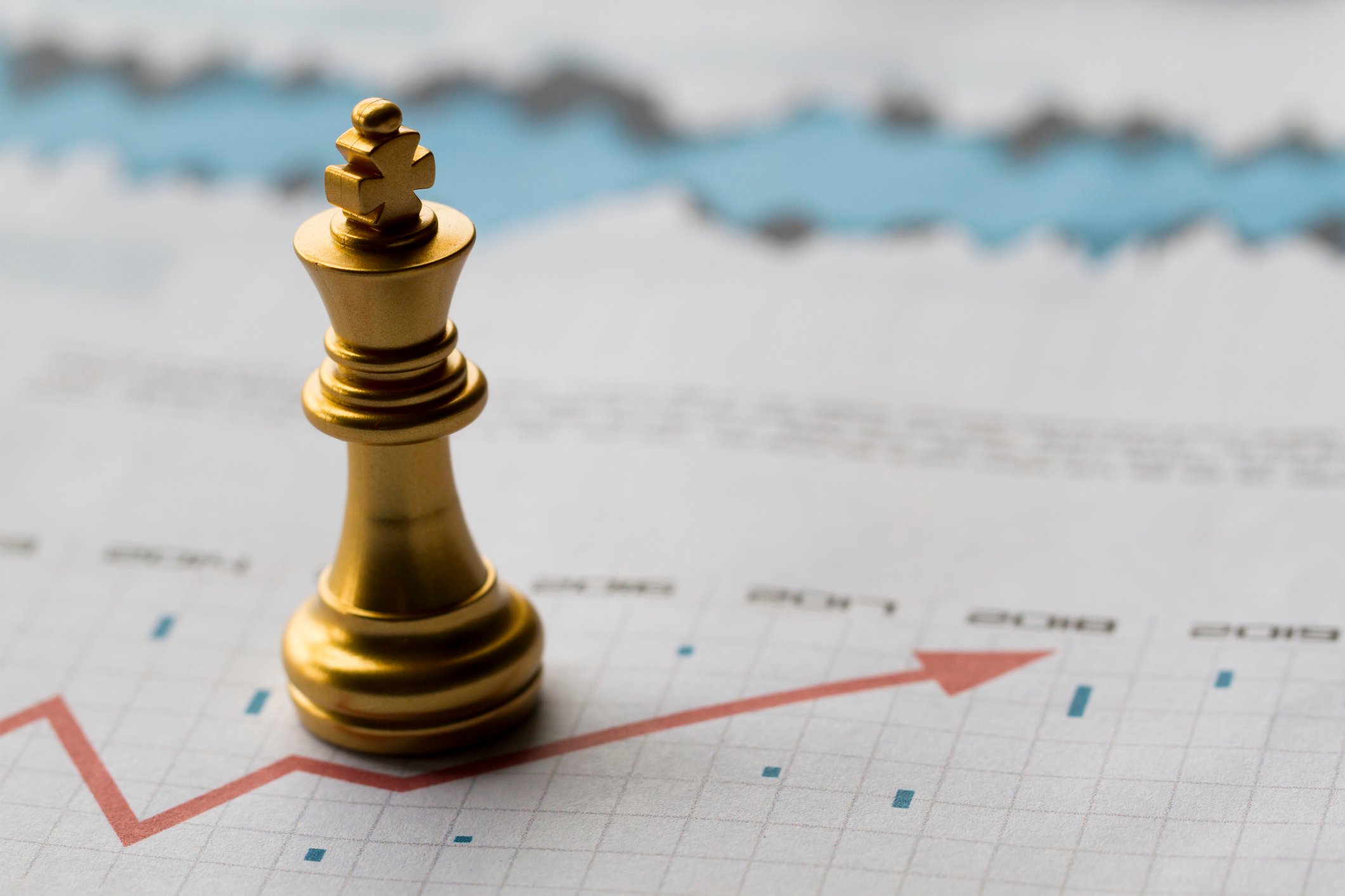 A king chess piece on a piece of paper displaying a chart line and data points.